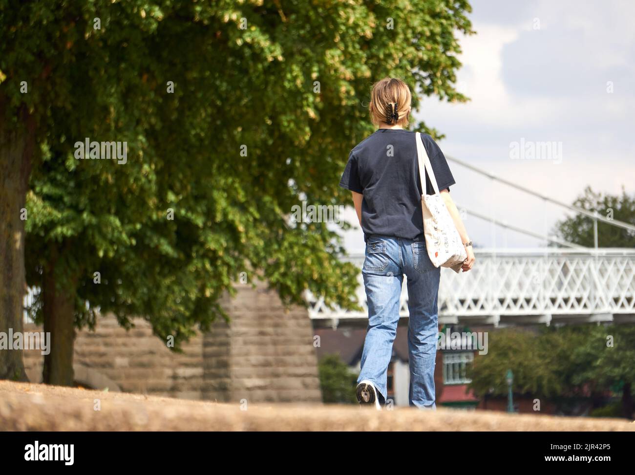 Girl walking outdoors in denim jeans and a t shirt Stock Photo