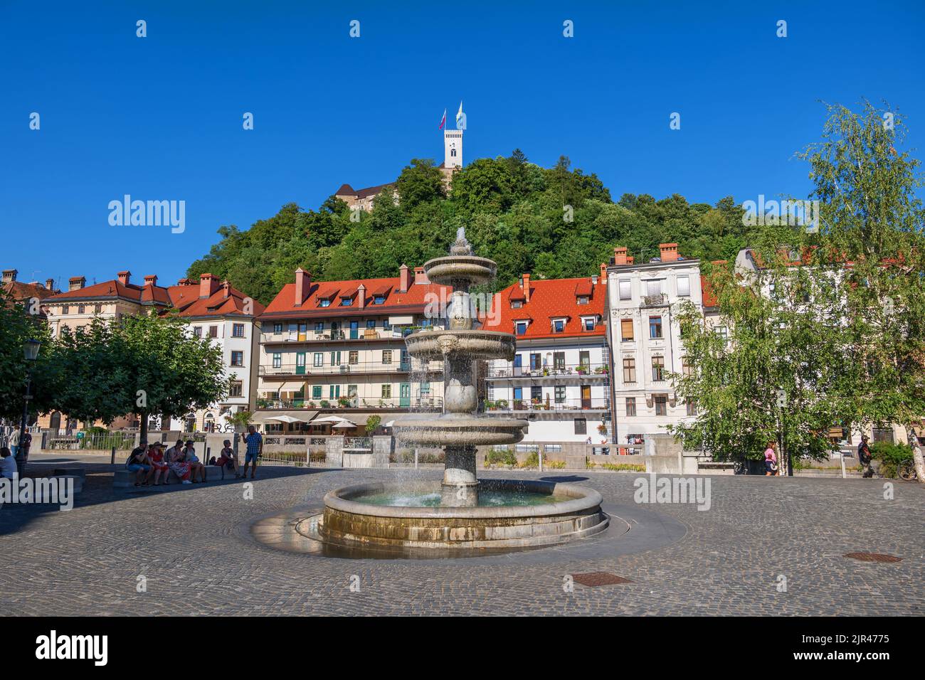 Ljubljana, Slovenia - July 13, 2022: New Square (Novi Trg) with a fountain and view to the Old Town and castle hill in capital city Stock Photo