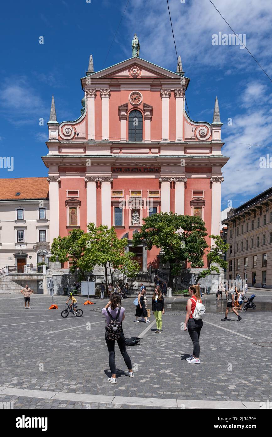 Ljubljana, Slovenia - July 14, 2022: People at Franciscan Church of the Annunciation at Preseren Square in historic city center Stock Photo