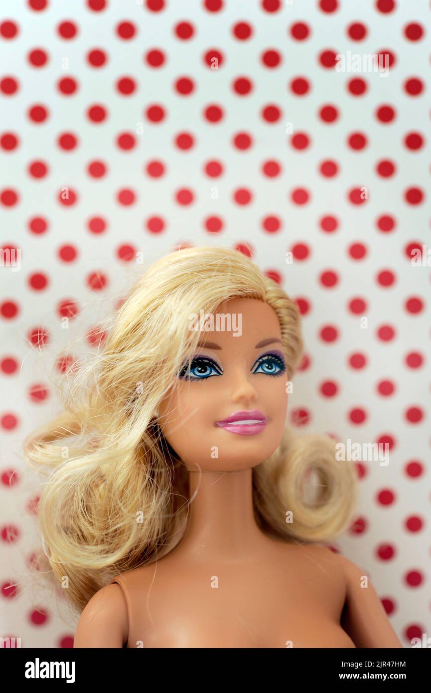 Blonde Barbie doll face close up with polka dots background Stock Photo