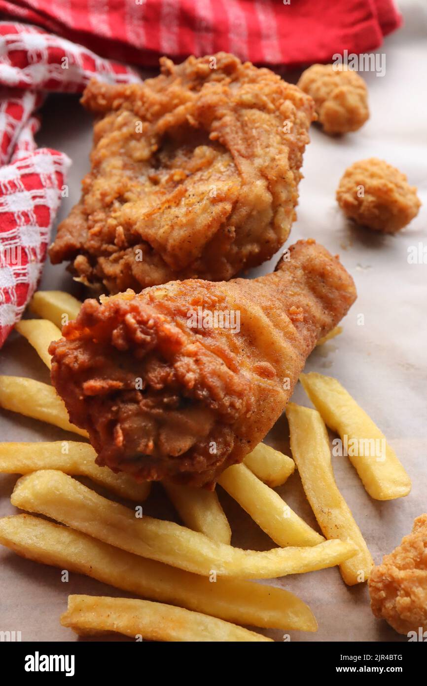 Battered fried chicken and chips. Fried chicken with a side of hot