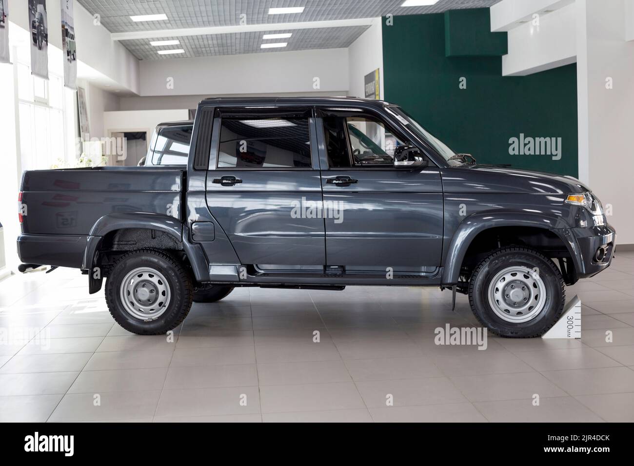 Russia, Izhevsk - August 20, 2021: UAZ showroom. New modern pick up UAZ Patriot in dealer showroom. Sollers automotive group. Side view. Modern cars. Stock Photo