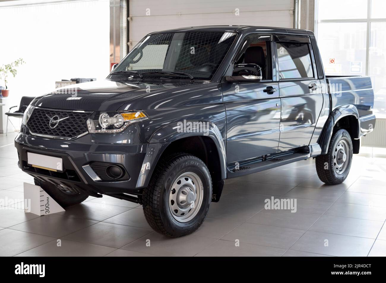 Russia, Izhevsk - August 20, 2021: UAZ showroom. New modern pick up UAZ Patriot in dealer showroom. Sollers automotive group. Front and side view. Stock Photo