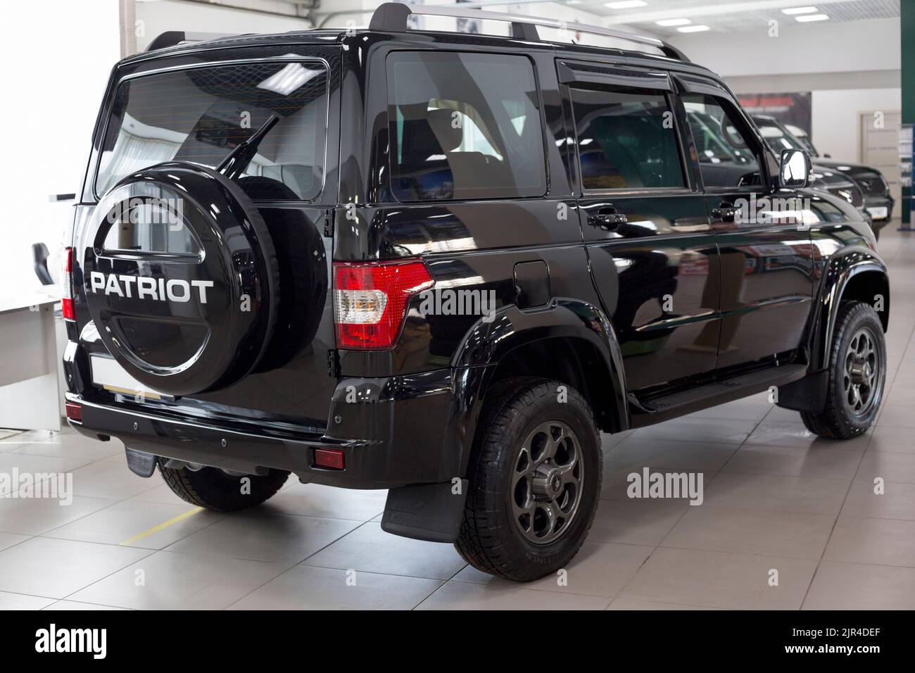 Russia, Izhevsk - August 20, 2021: UAZ showroom. New modern UAZ Patriot car in dealer showroom. Back and side view. Sollers automotive group. Stock Photo