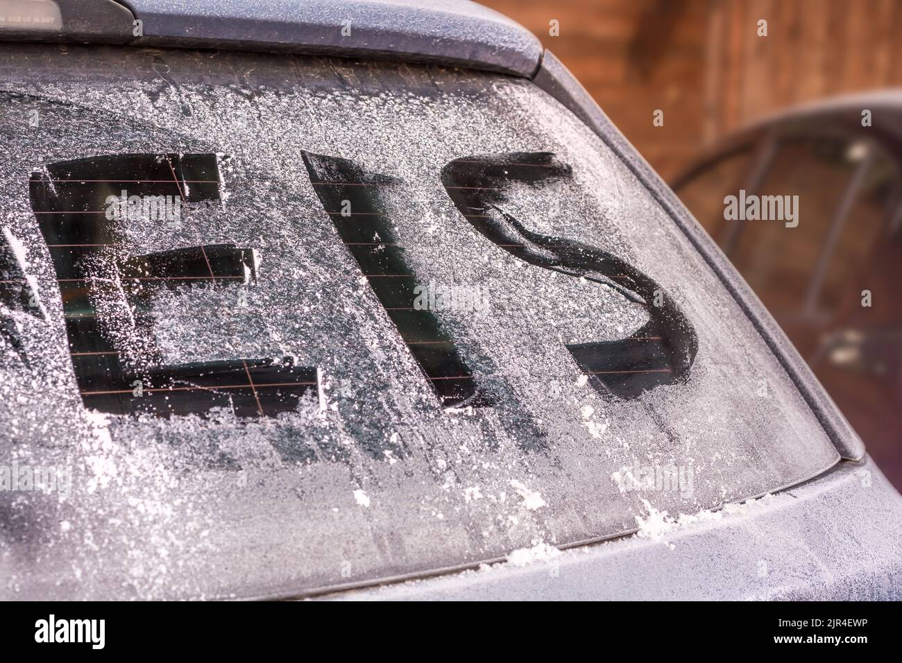 Icy rear window of a car with the german word for ice Stock Photo