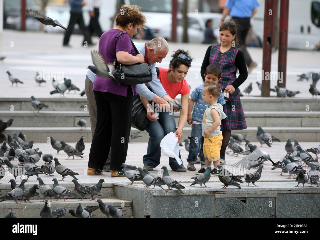 A man holding a pigeon shows it to a boy in Guvercin Yemleme Alani, a park at Ankara in Turkey. Stock Photo
