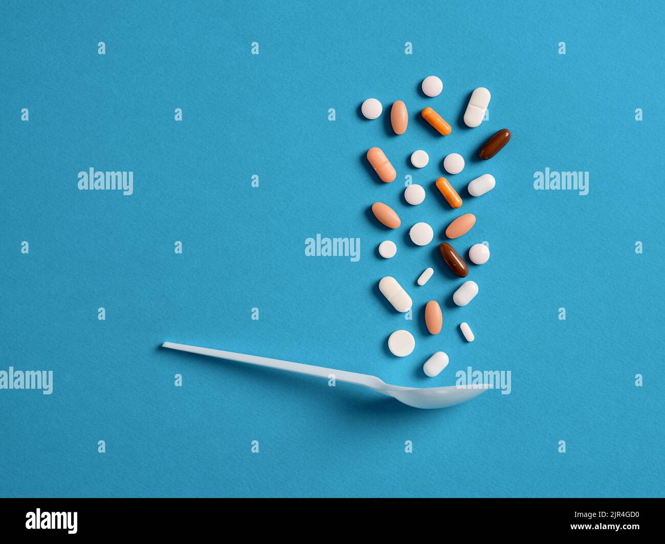 Medical pills are falling into a spoon. Drug overdose, abuse or