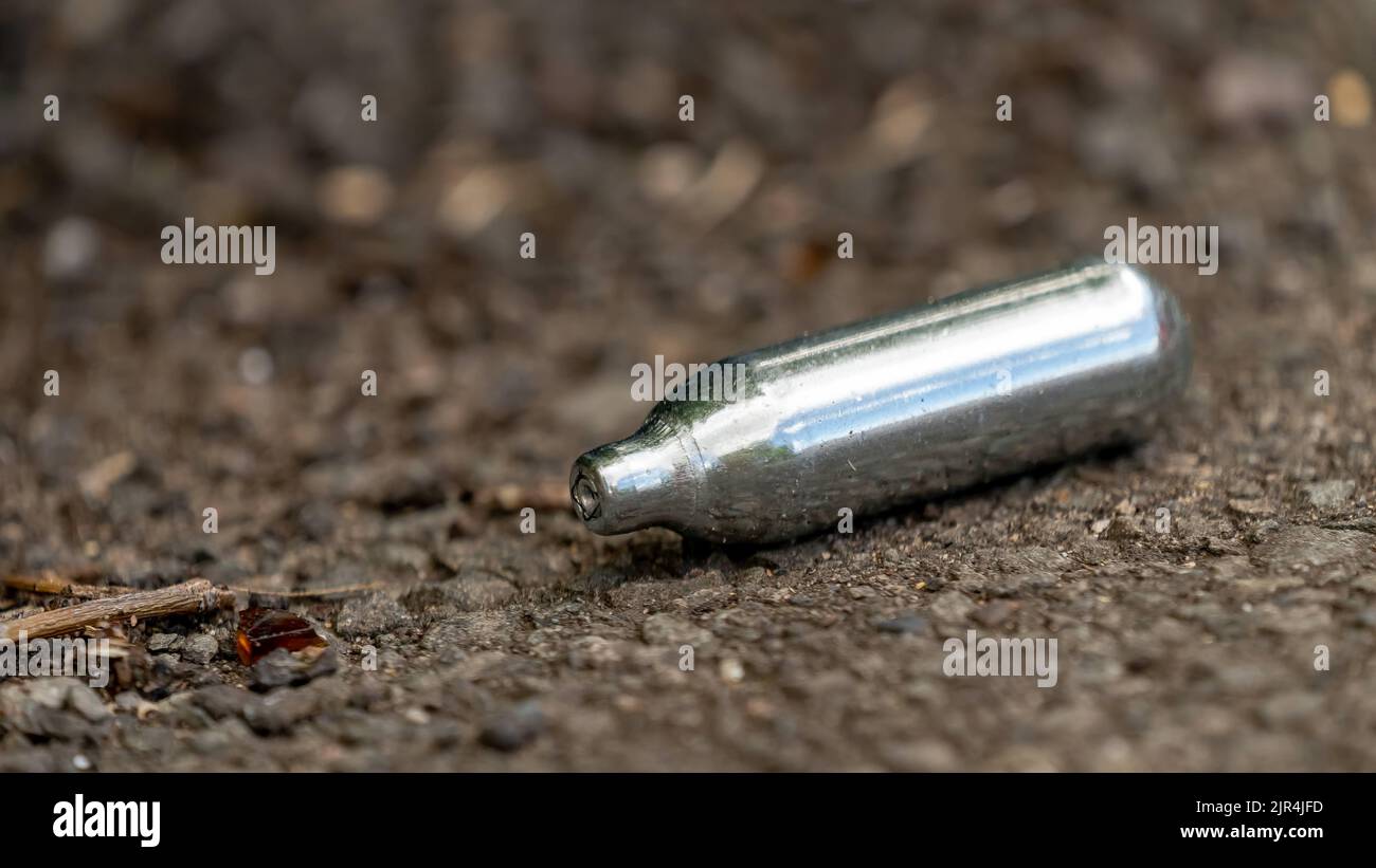 Close-up of a discarded Nitrous oxide gas canister Stock Photo