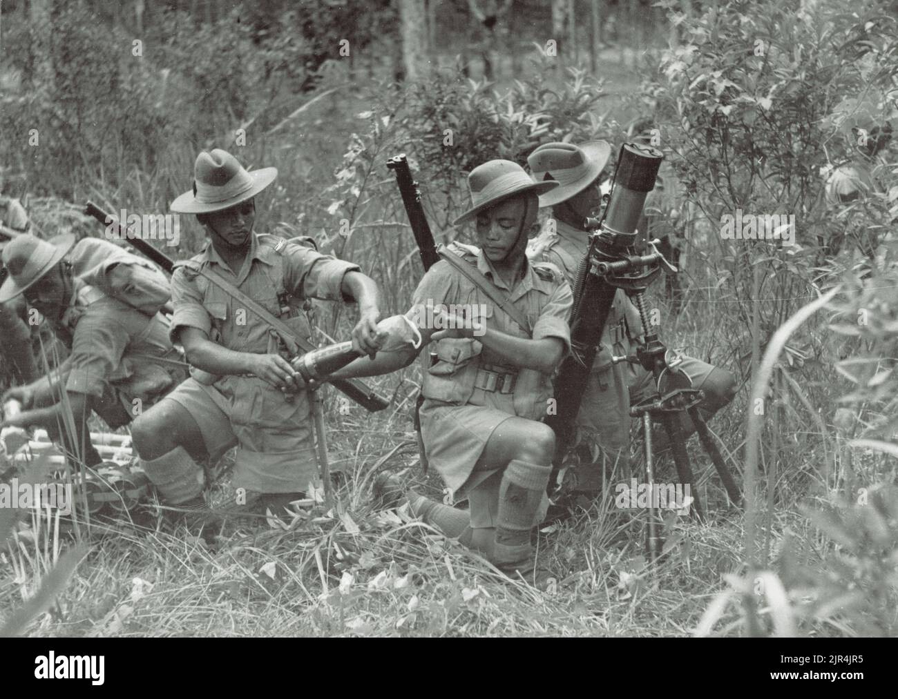 A vintage photo circa 1941 showing soldiers of the 9th Gurkha Rifles British Indian Army manning a mortar position in the jungle during the Japanese invasion of Malaya and the fall of Singapore Stock Photo