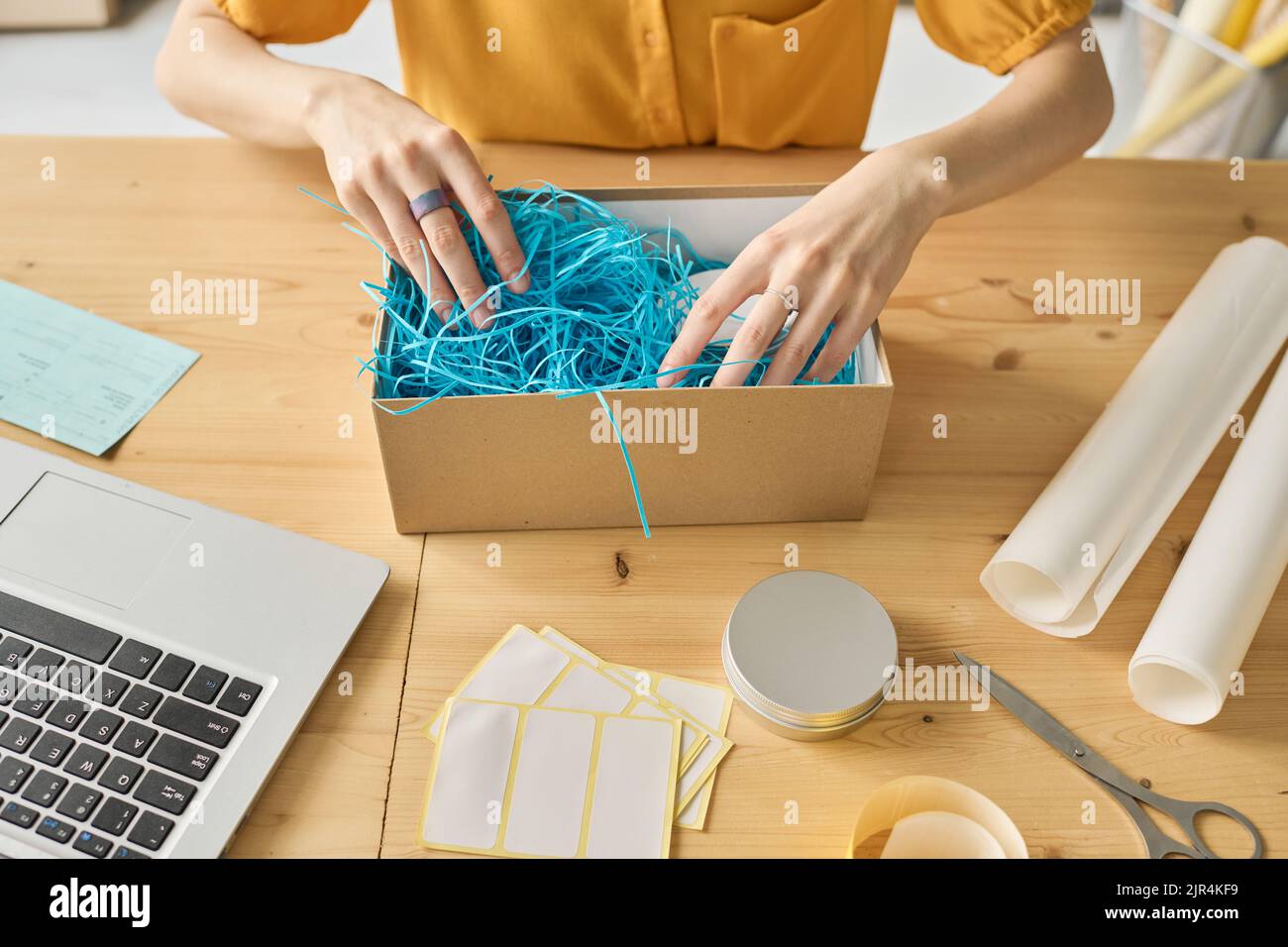 High angle view of young woman working with online order to pack goods in cardboard box Stock Photo