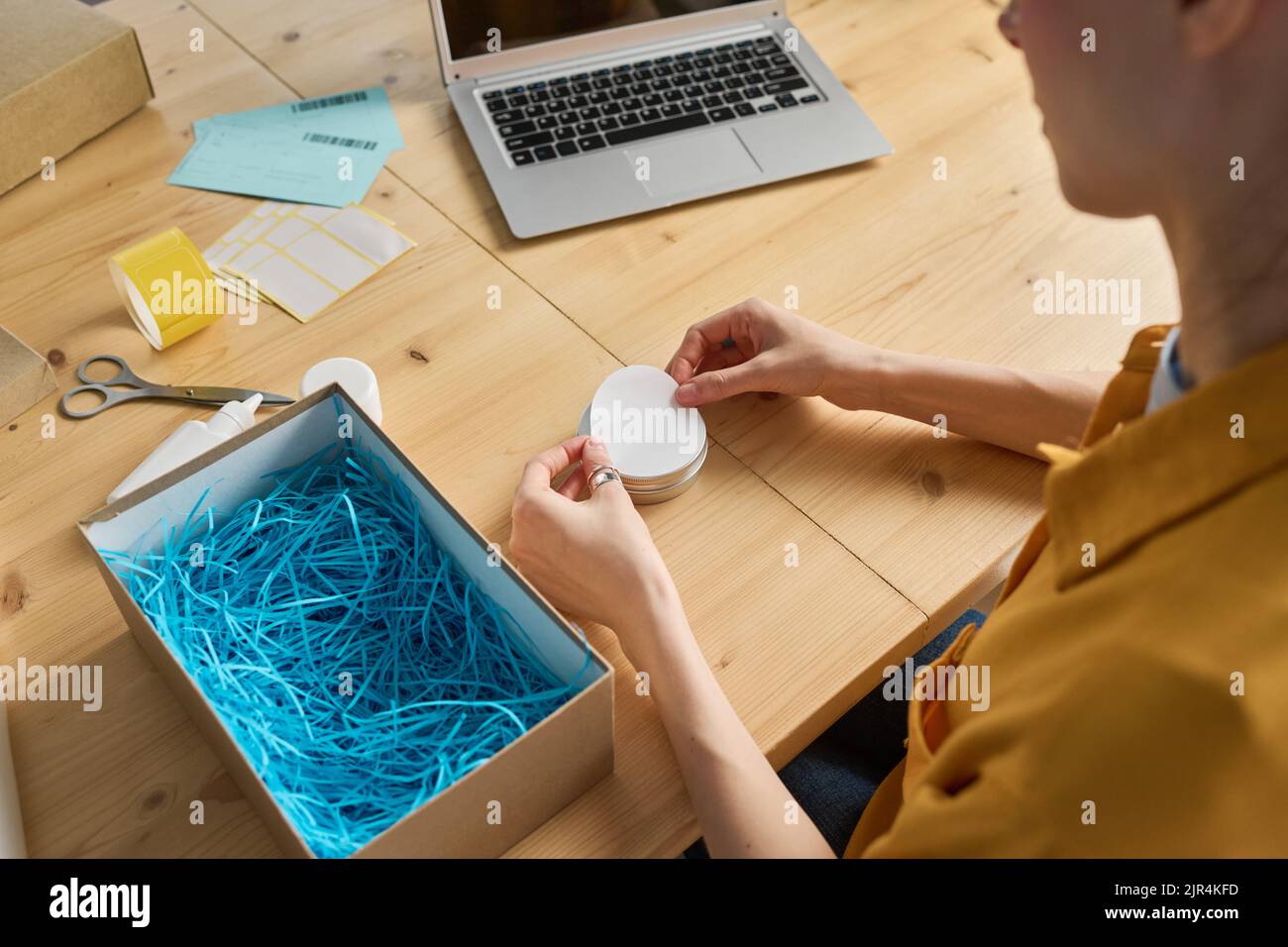 Close-up of woman working with online orders at table to pack parcels for delivery Stock Photo