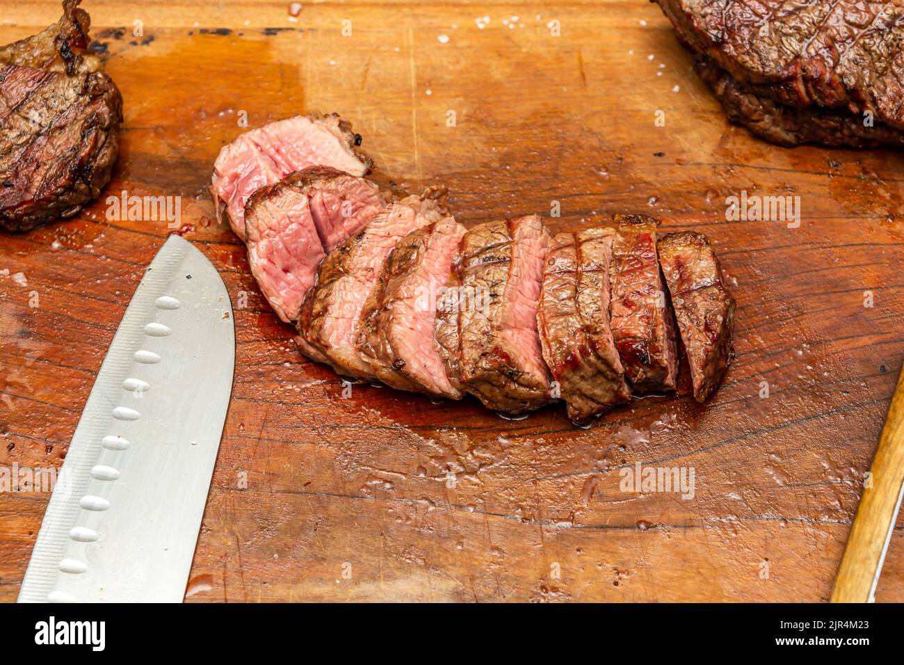 medium rare tritip steak sliced on a cutting board Stock Photo Alamy