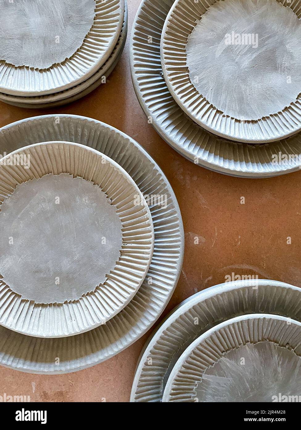 Stacks of leather hard ceramic plates before being bisque fired Stock