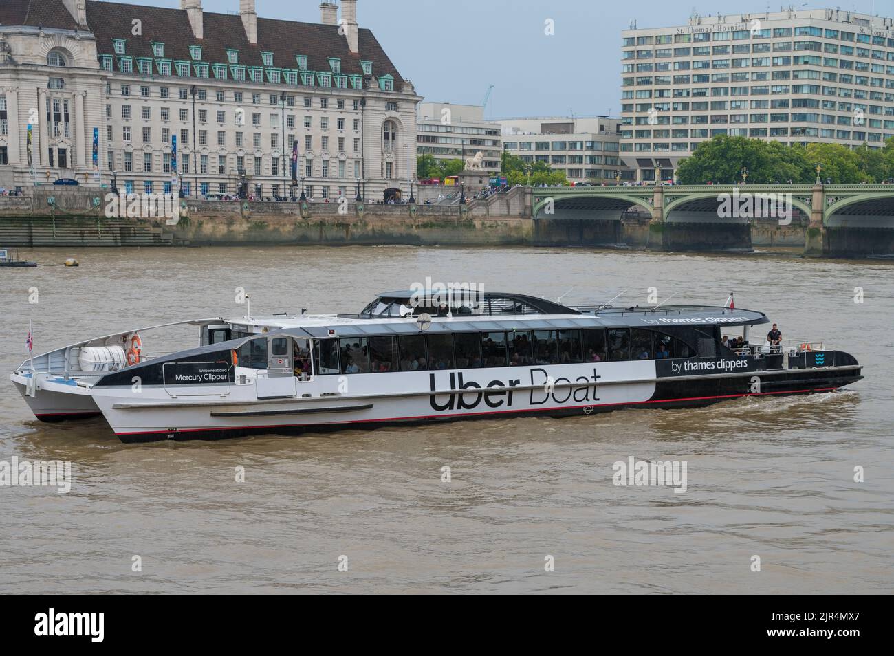 Mercury Clipper, MBNA Thames Clippers Uber Boat river bus vessel reversing to dock at Westminster Millennium Pier, London, England, UK Stock Photo