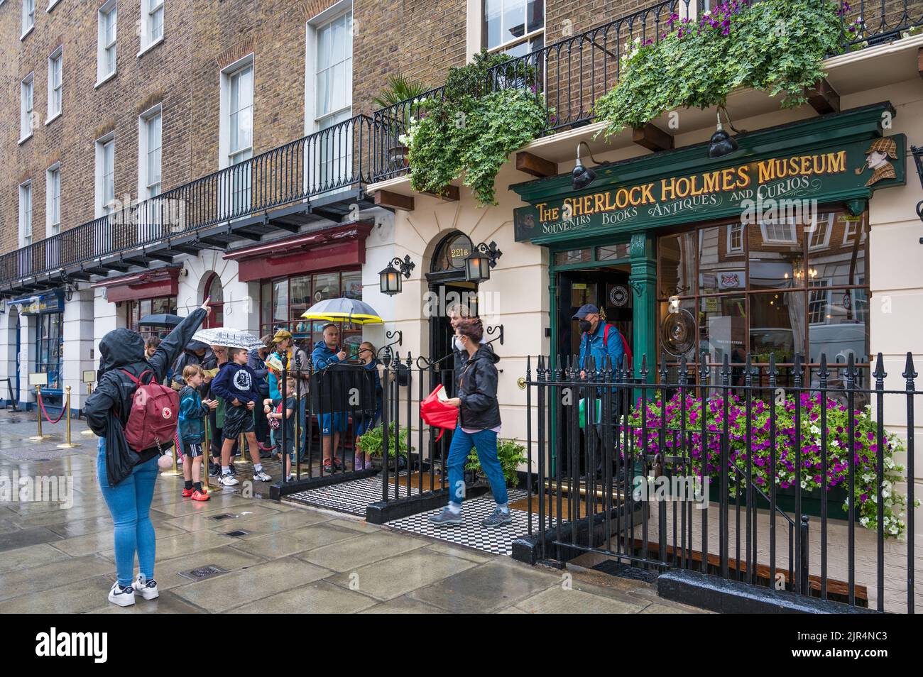 People queuing outside on a rainy day waiting for entry to the Sherlock Holmes Museum. Baker Street, London, England, UK Stock Photo