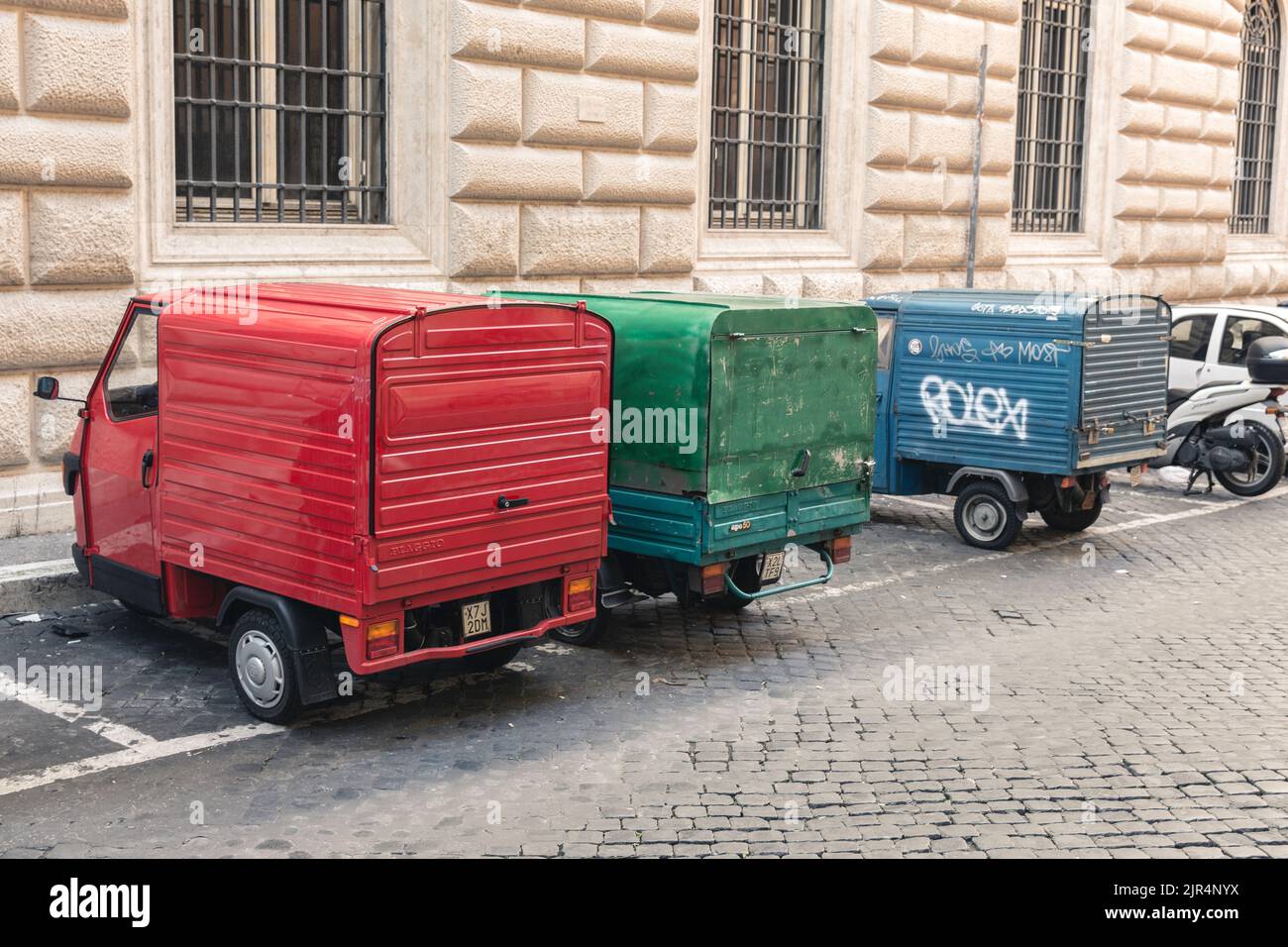 The colorful classic Piaggio APE three-wheelers parked on the street Stock Photo