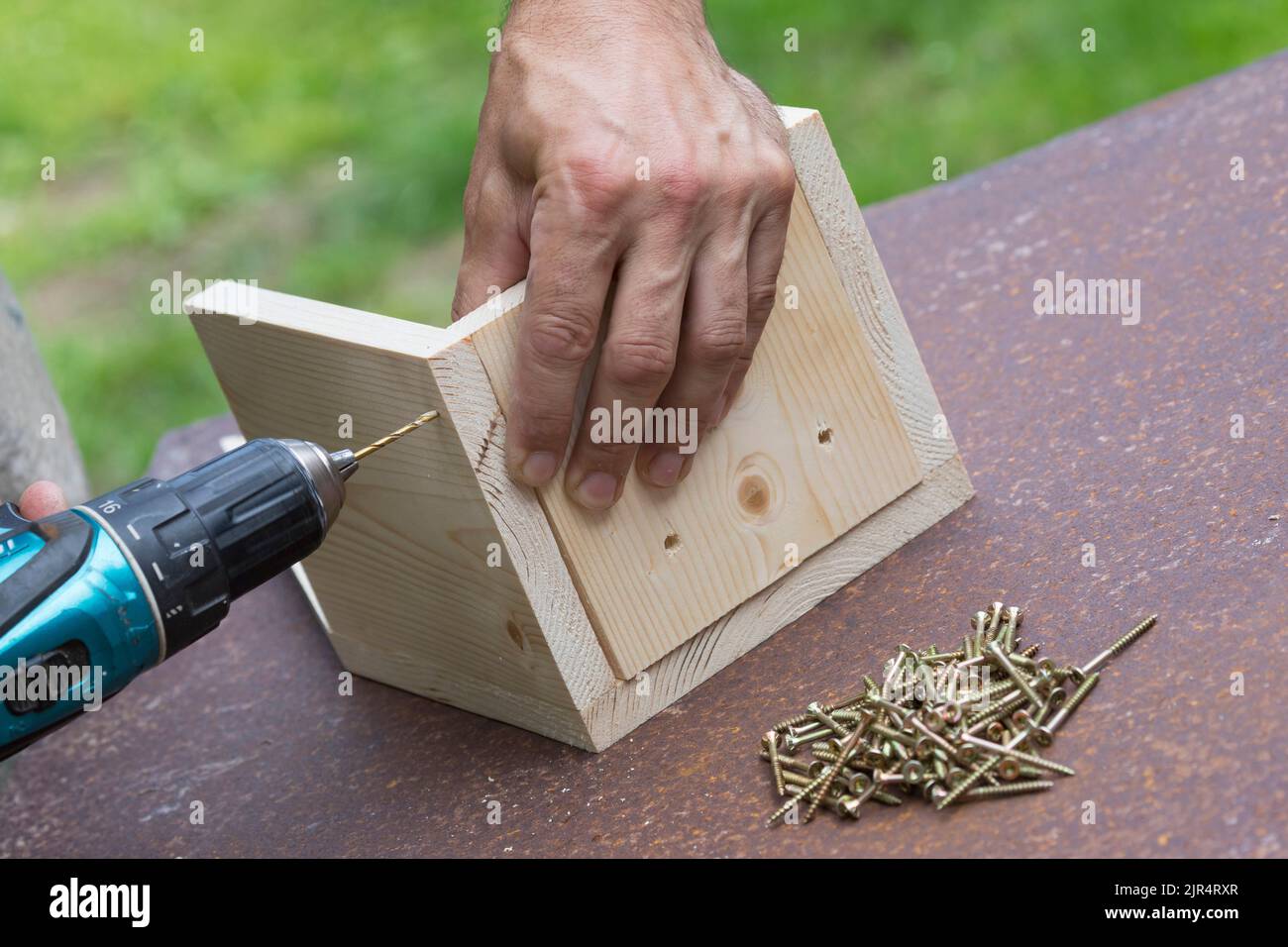 nest box series, step 4/13: screw the base plate to the side parts and the back wall, pre-drill beforehand Stock Photo