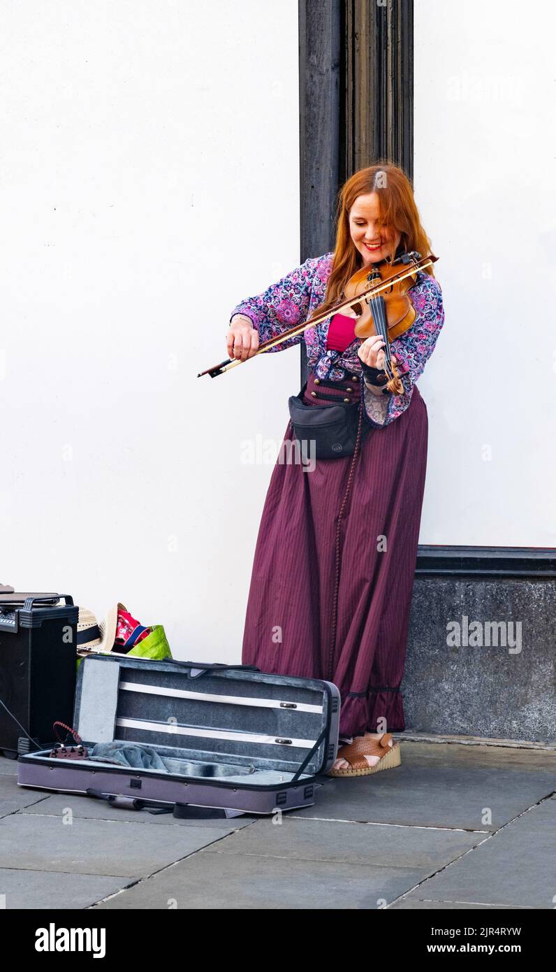 Smiling female Irish fiddle player on Bold Street in Liverpool Stock Photo