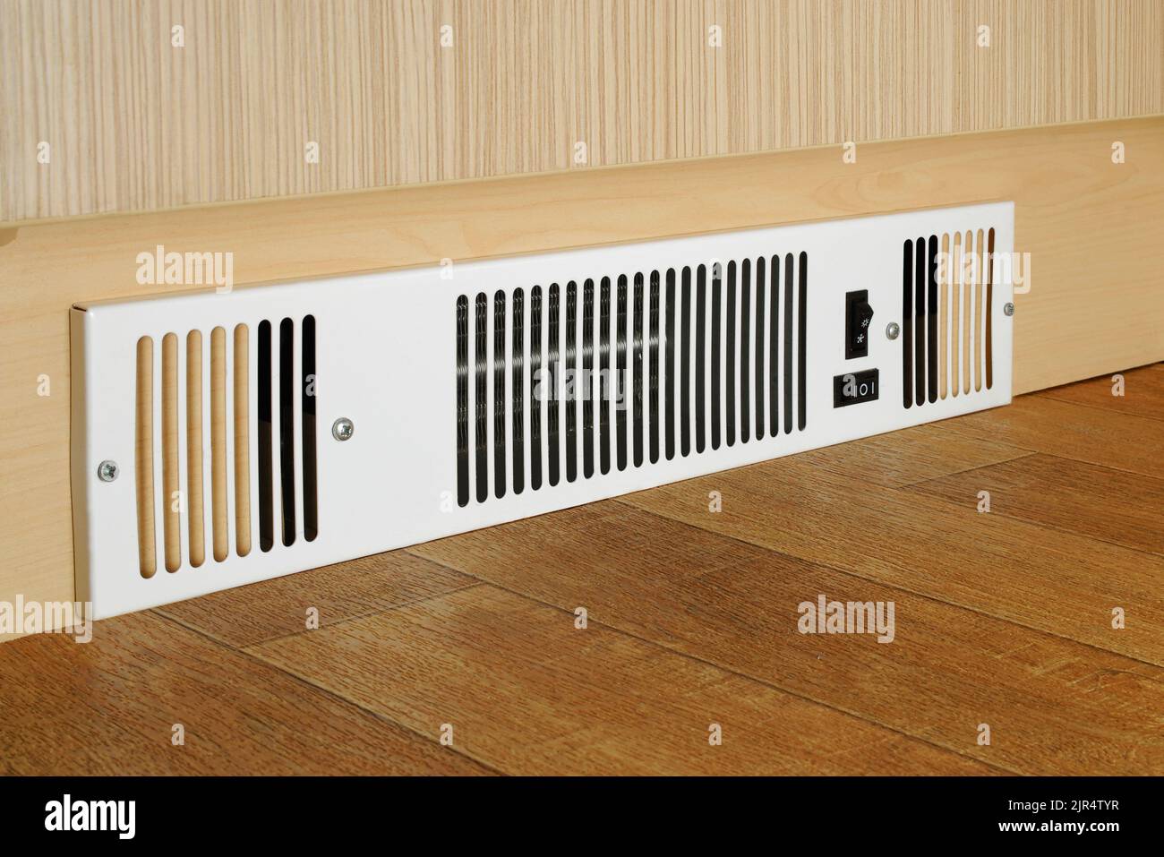 A floor level electric fan heater fitted into a kitchen kickboard Stock Photo