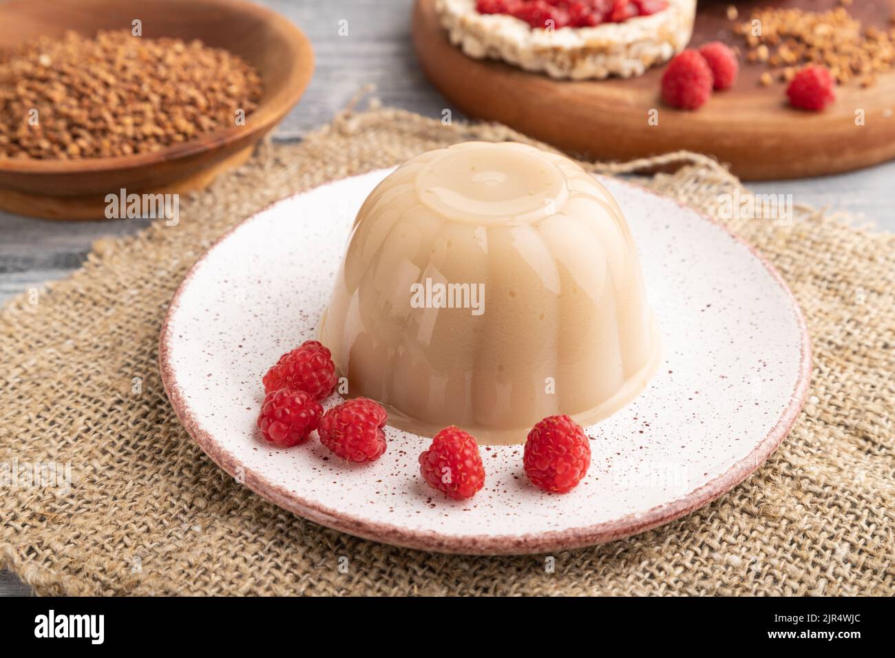 Buckwheat milk jelly on gray wooden background and linen textile. side view, close up Stock