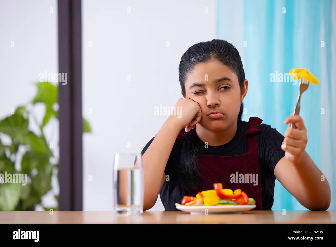Portrait of a little girl expressing unhappiness over a plate of vegetable salad Stock Photo