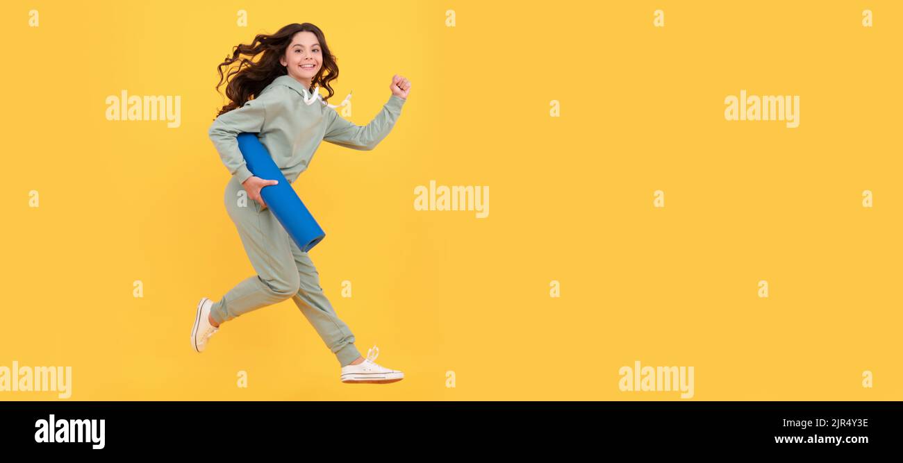 glad child in sportswear running with fitness mat. fit your body. sport teen girl training. Horizontal poster of isolated child face, banner header Stock Photo