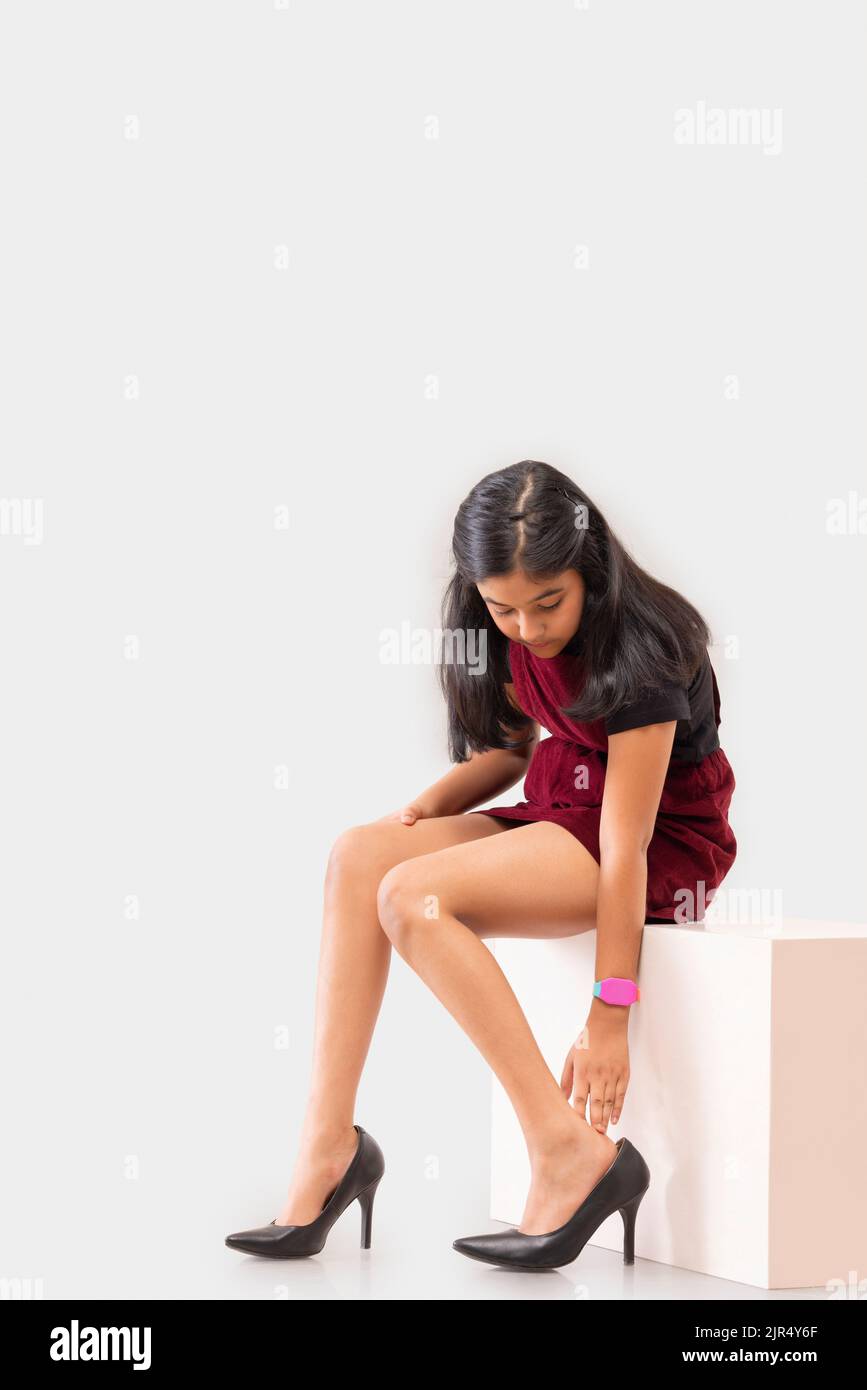 Portrait of little girl trying on high heel shoes Stock Photo Alamy