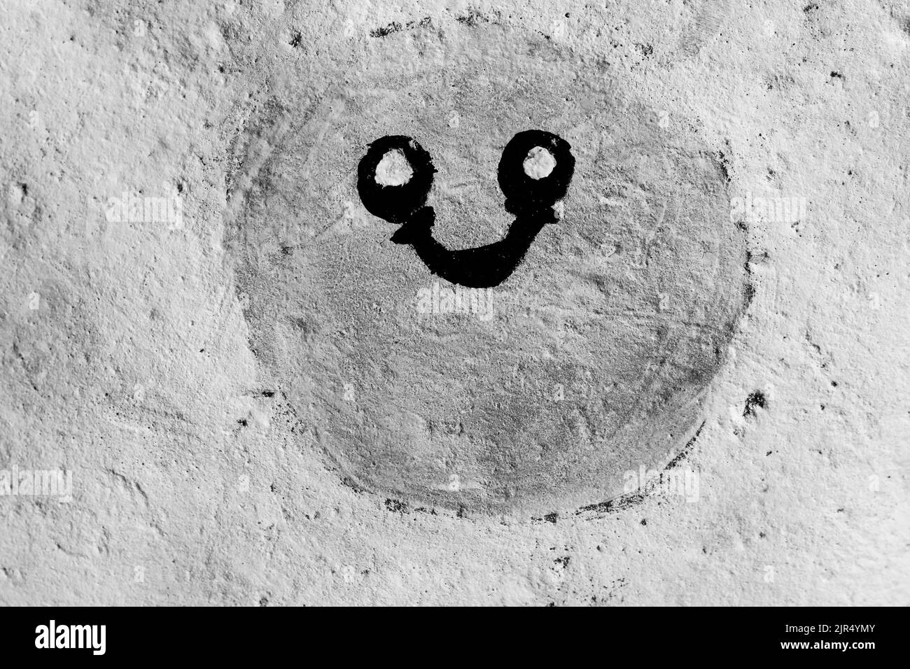 Cute smiley face grinning back at me in black and white monochrome. Stock Photo