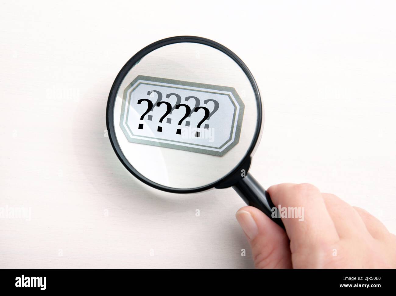 Concept of person seeing double. Person hand holding magnifying glass and looking text and seeing it double and blurred. Stock Photo