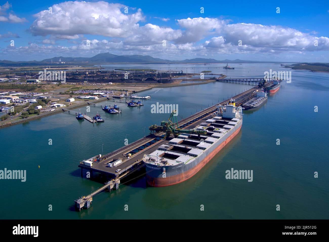 Aerial view of cargo ships docked at a busy industrial port with clear ...