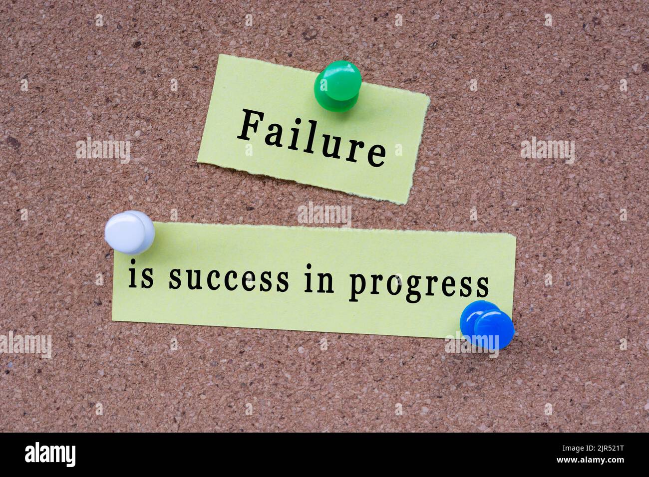 Failure is success in progress words on stick note and pinned to a cork
