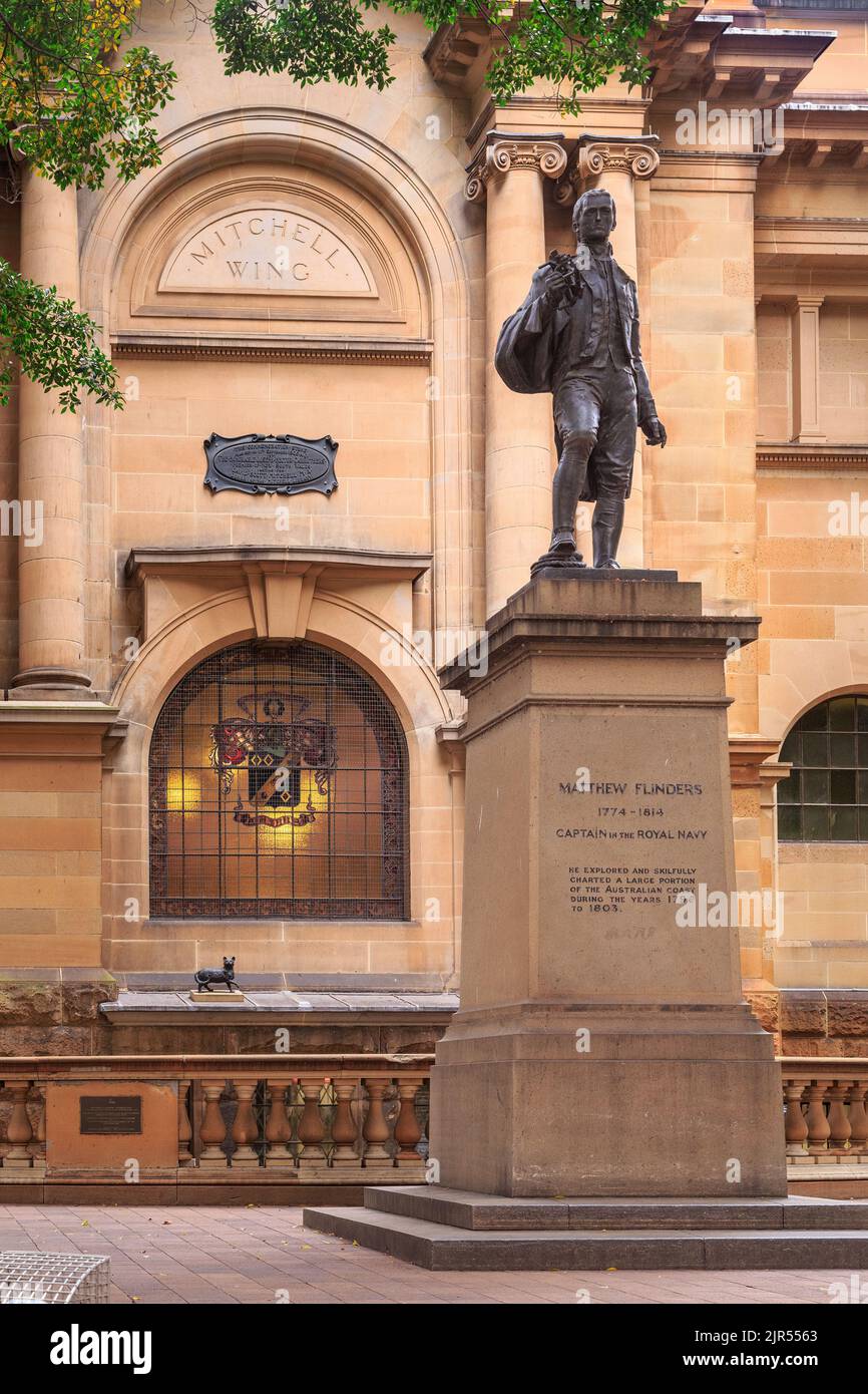 A statue of the English explorer Matthew Flinders outside the Library of New South Wales, Sydney, Australia. Behind him is a sculpture of his cat Trim Stock Photo