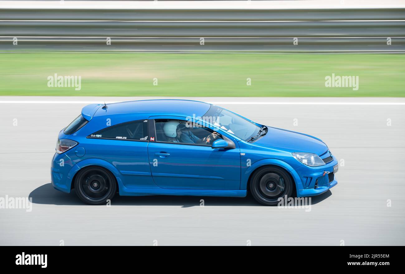A blue third generation Opel Astra OPC running on the race track Stock Photo