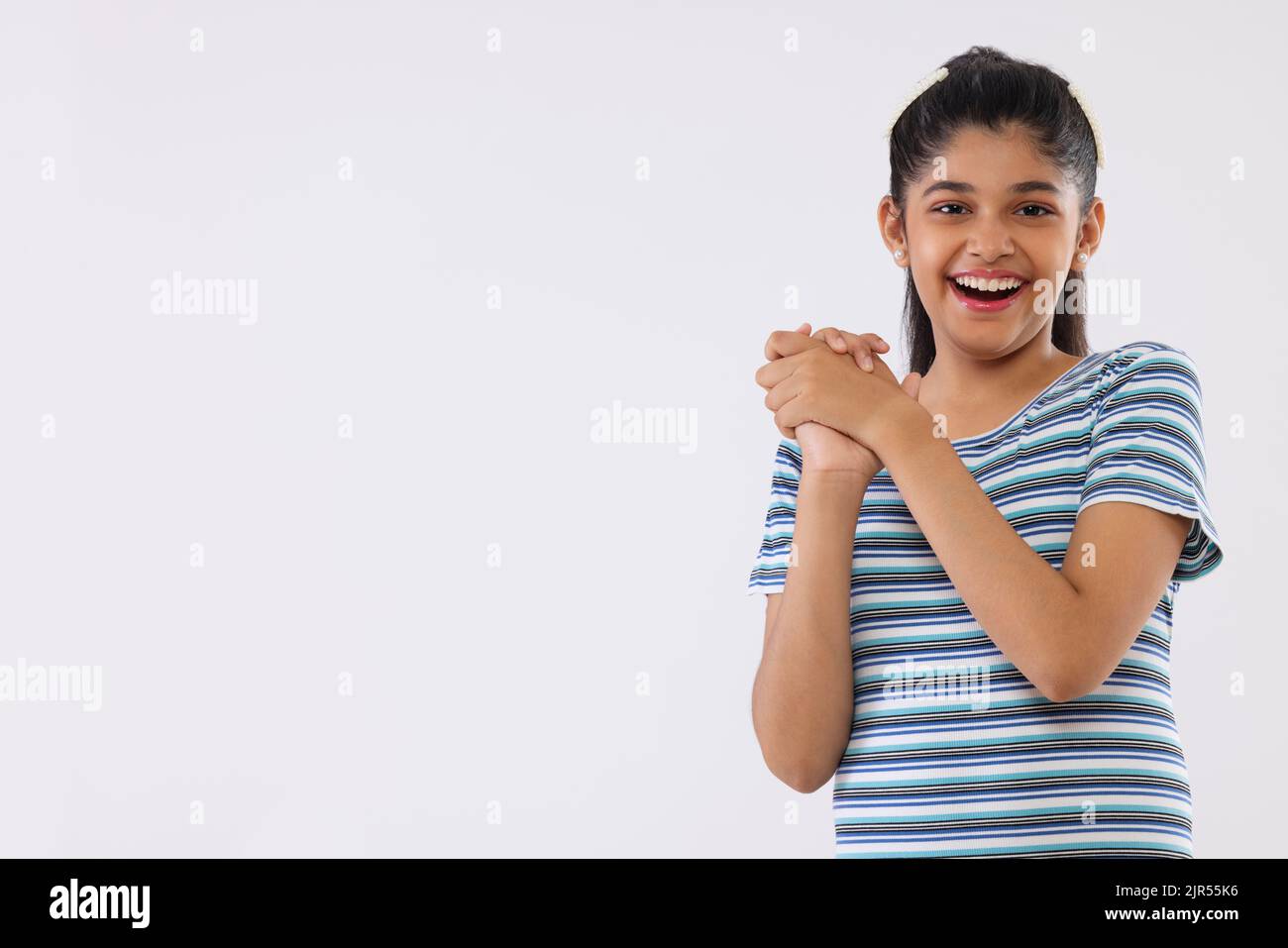 Portrait of a cheerful girl gesturing against white background Stock Photo