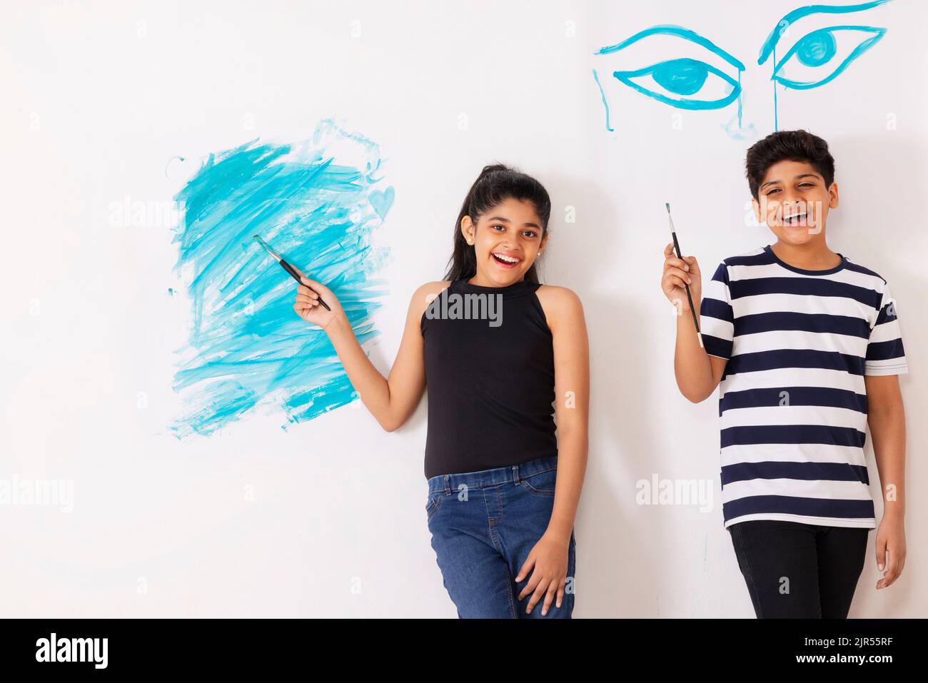 Cheerful children drawing together on white wall Stock Photo - Alamy