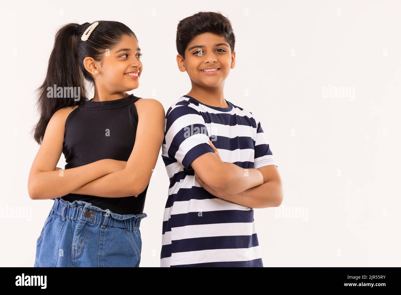 Cheerful boy and girl standing together with crossed arms Stock Photo
