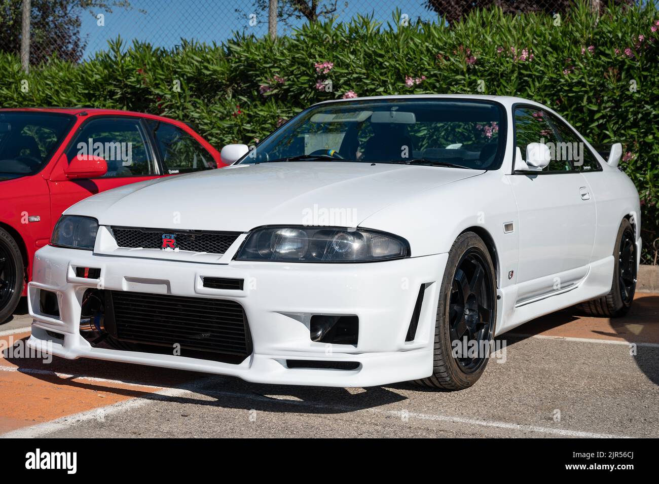 A white Nissan Skyline GT-R R33 parked on the street Stock Photo