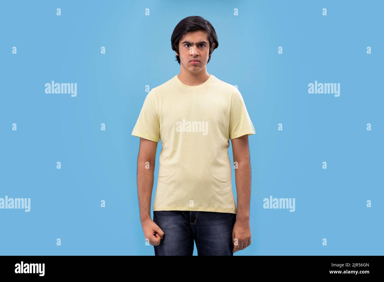 Portrait of an angry teenage boy against blue background Stock Photo ...