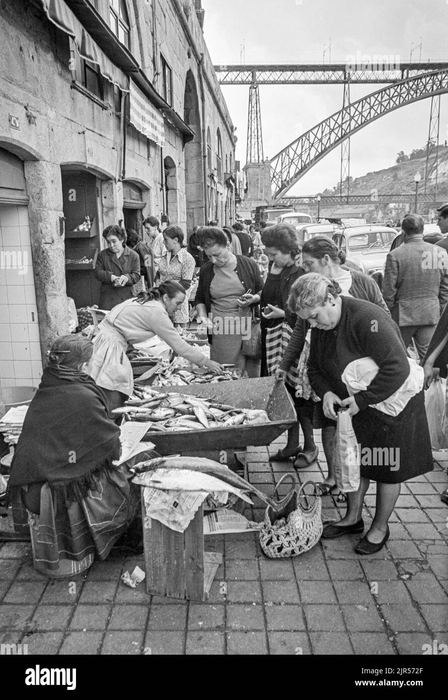 PORTUGAL - PORTO -  1970. Women buying fish at a market by the river in the Ribeira district of Porto, Northern Portugal.  Copyright Photograph: by Pe Stock Photo