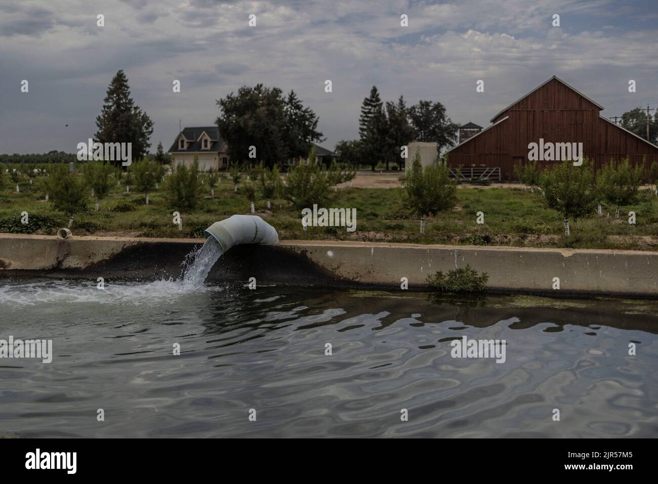 Water Emerges From A Pipe At An Irrigation Canal While Extreme Weather Conditions Including 