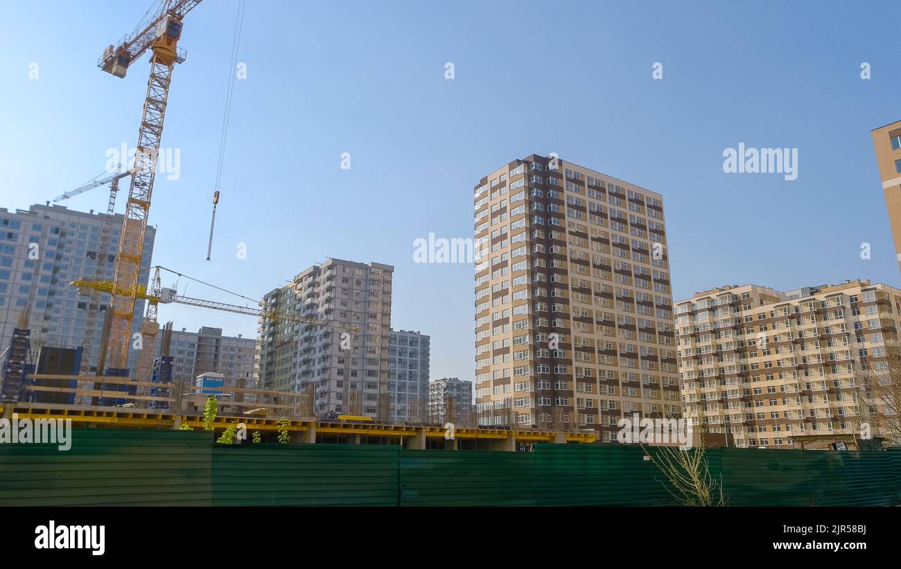 High-rise buildings under construction and cranes. Blue sky background ...