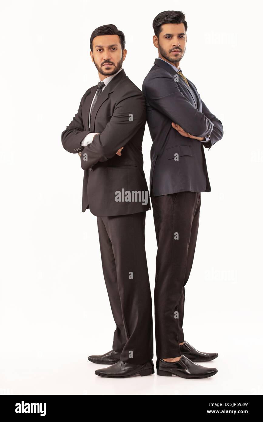 Two Men Standing Back To Back Against A White Background Stock