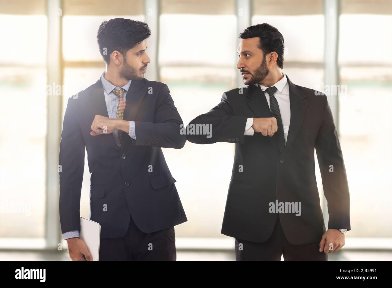 Corporate employees in formal business suit standing with their elbows