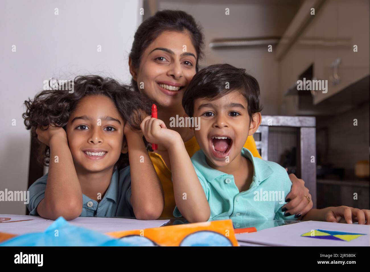 Mother with her children posing in front of camera during painting Stock Photo