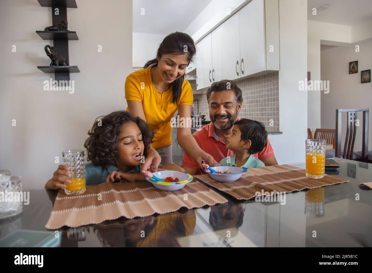 Portrait of a nuclear family at breakfast table in living room Stock Photo