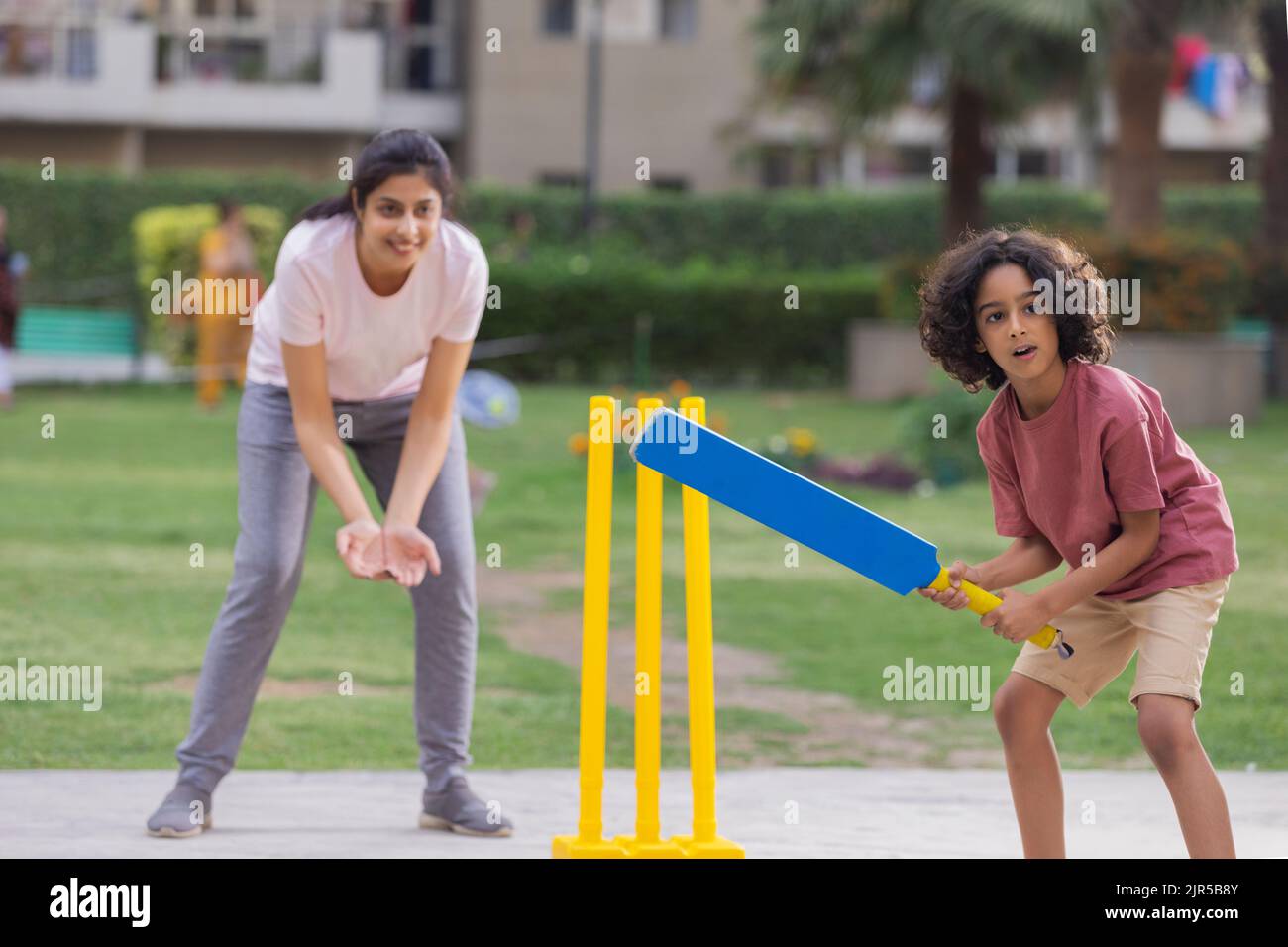 Family playing cricket in the park Stock Photo