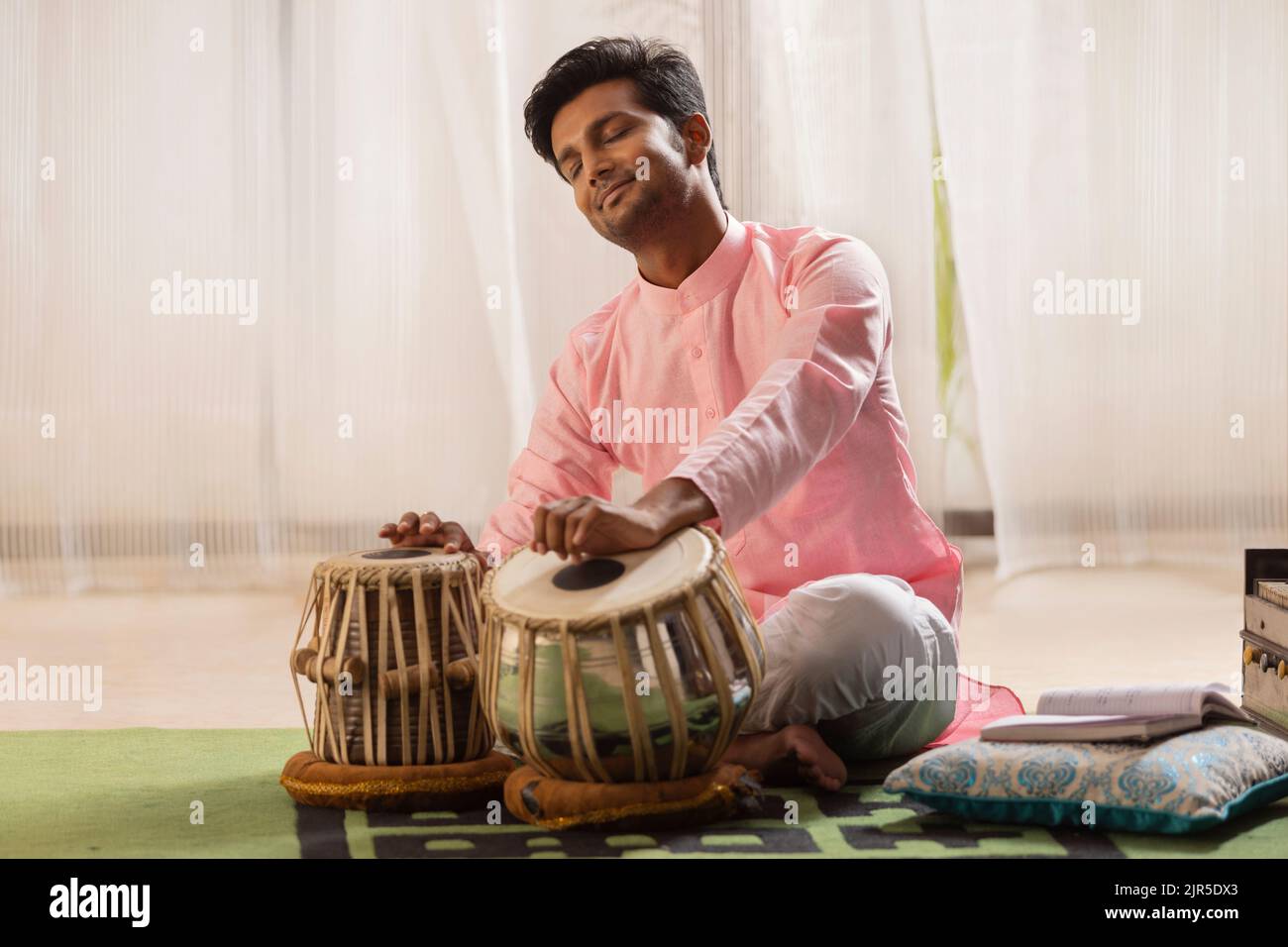 Portrait of young man playing Tabla at home Stock Photo Alamy