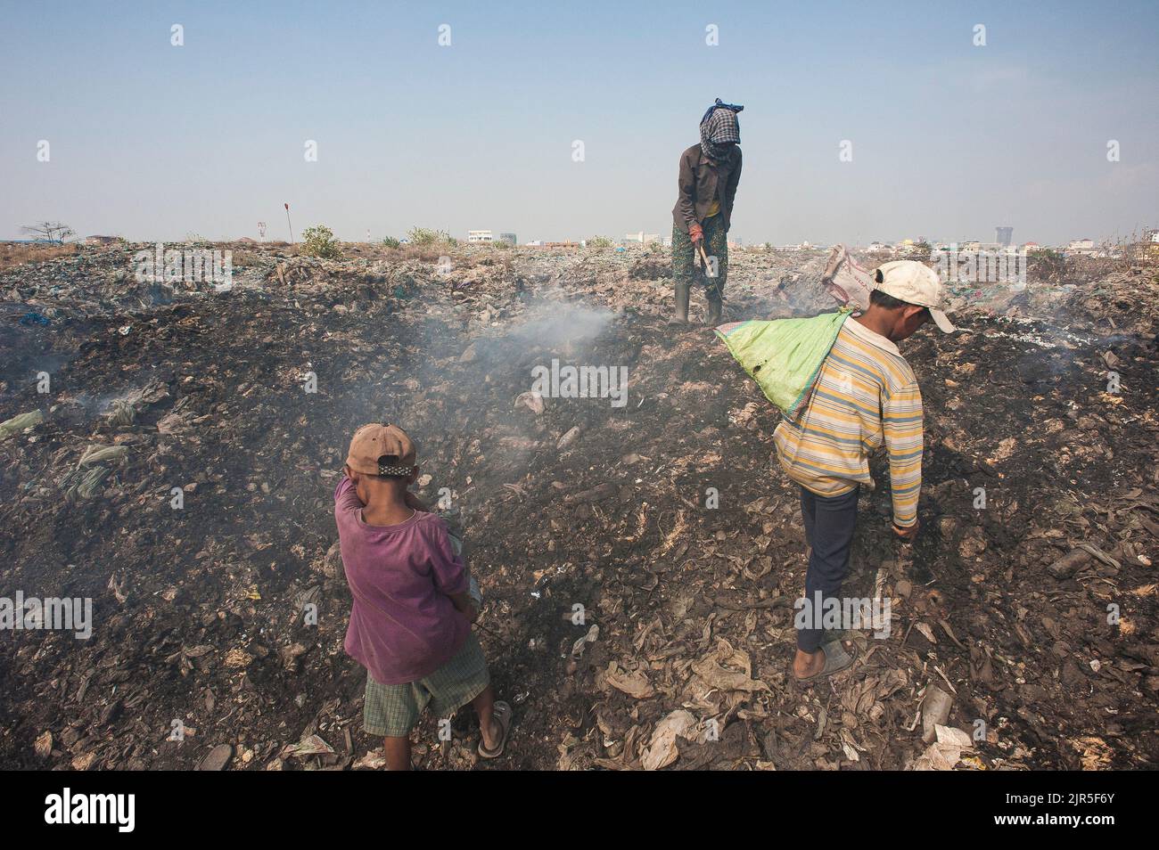 Phom Penh, Cambodia - February 06, 2011: Poor family collecting recyclable waste in the Stung Meanchey trash landfill in the outskirts of the city Stock Photo