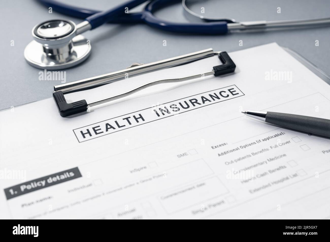 Health Insurance form and stethoscope on desk Stock Photo