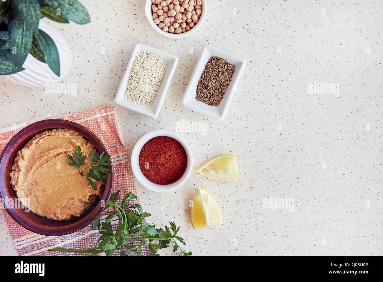 Hummus with chickpeas and tahini sauce in the bowl parsley, lemon